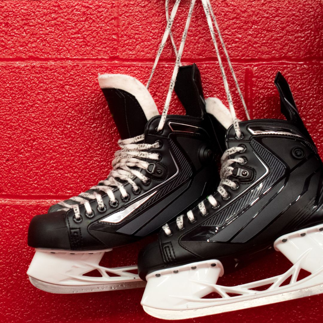 Skates hanging on red background